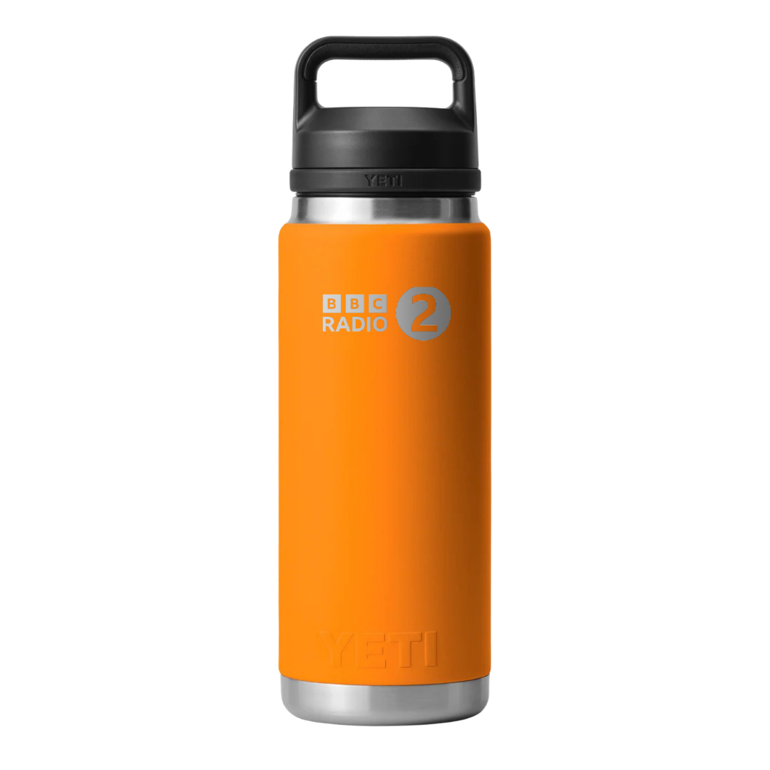 A BBC Radio 2 Click & Collect 2026 Yeti Bottle in orange with a black lid, featuring the BBC Radio 2 in the Park logo in white and gray on the front.