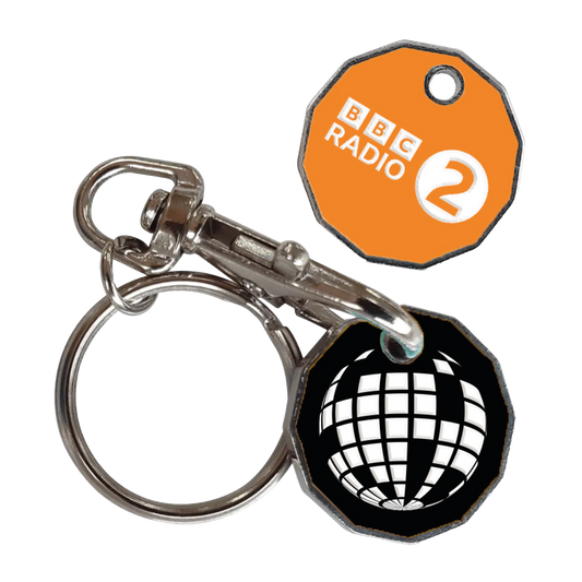 The 2025 Radio 2 In The Park Trolley Token features two tokens—one orange with the BBC Radio 2 logo, one black with a white globe—attached to a metal keyring and clasp.